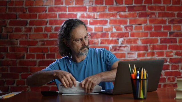 Frustrated man with stress doing budget tax paperwork throwing papers into the air.