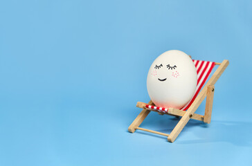 Creative composition with Easter egg sitting on deck chair
