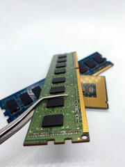 RAM chip on pincer closeup with other chips on white background