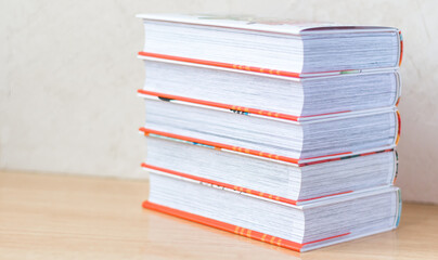 A stack of books On a light background on the table. Copy space