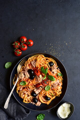Pasta spaghetti with tuna, tomatoes and olives. Top view with copy space.