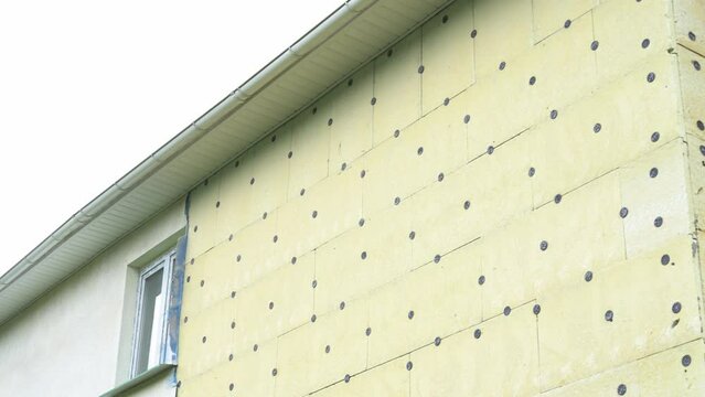Insulation of a residential building. Exterior repair work on the building, insulation and cladding of the facade of the house. High quality 4k footage