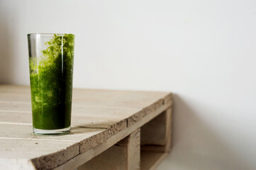Glass with green juice with signs that it has already been drunk