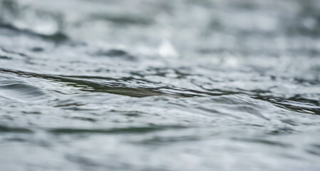 Smooth water river surface only small waves, closeup abstract detail with shallow depth of field focus