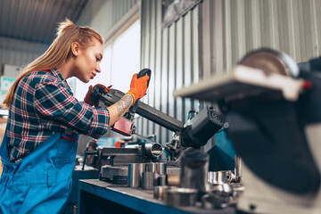 Destroying gender stereotypes. Young woman auto mechanic working at auto service station using...