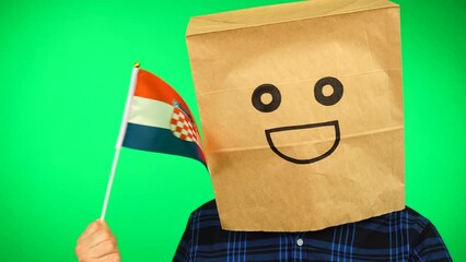 Portrait of man with paper bag on head waving Croatian flag with smiling face against green background. - Powered by Adobe