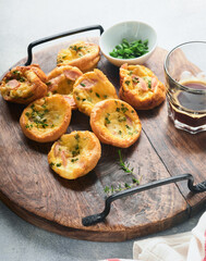 Obraz na płótnie Canvas Delicious egg muffins with green onions, bacon, cheese and tomatoes on wooden board on light background. Healthy high protein and low carb breakfast. Homemade food.