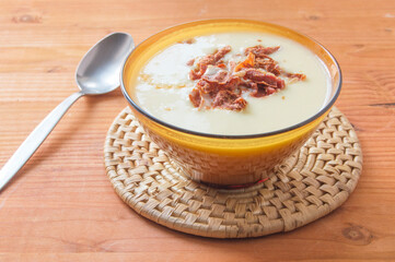 bowl with leek and ham cream, isolated on a wooden board
