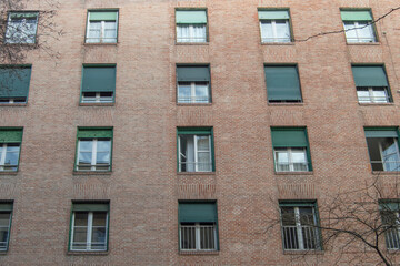 brick facade with rectangular windows of a building from the 30s in Madrid. Spain
