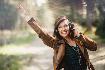 Woman Listening Music While Walking Along Forest Path
