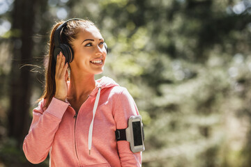 Woman Runner Is Listening To Music And Preparing To Jogging Outdoors