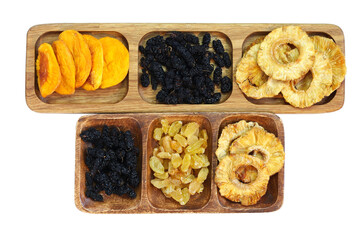 Dried fruits on wooden plates divided into sections. Dried peach, mulberry, raisin and pineapple. Isolated on white background.