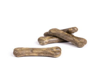 Large dog chew bones for fresh breath. Multiple dog treat sticks in bone shape for strong teeth, better gums and breath. Dental health treats for dogs. Selective focus on one bone. Isolated on white.
