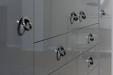 Modern round knobs on a polished cabinet. Manufacture of modern furniture.