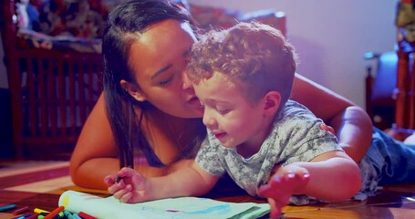 a mother is drawing with crayons in a notebook together with her son - Powered by Adobe