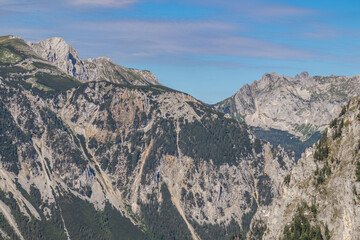 Panoramic view on the alpine mountain chains in Styria, Austria, Hochschwab region. Hills overgrown with small bushes, higher parts rocky and bare. Sunny summer day. Serenity. Hiking in Alps, Tragoess