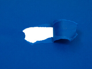 Blue paper damaged torn with white hole isolated copyspace for text
