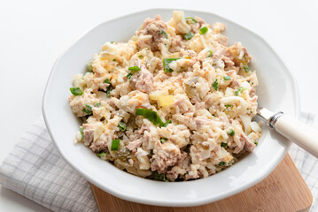 Salad with rice, tuna, egg, pickled cucumber, and chives.