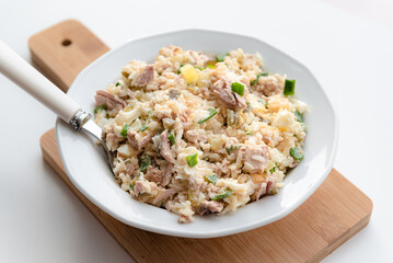 Salad with rice, tuna, egg, pickled cucumber, and chives.