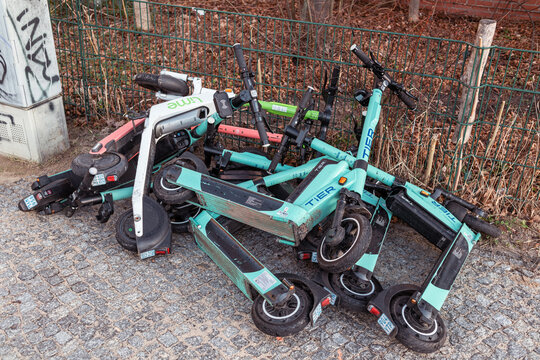 Berlin, Germany, 02.22.2022, a pile of motorized electric City scooters piled on top of each other on a pavement in berlin.