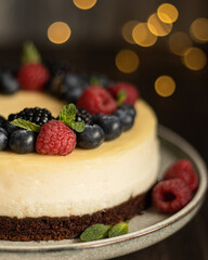 Close up cheesecake decorated with blueberry, raspberry, blackberry and leaves of mint