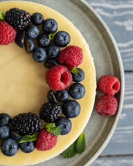 Close up cheesecake decorated with blueberry, raspberry, blackberry and leaves of mint
