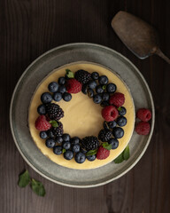 Cheesecake decorated with blueberry, raspberry, blackberry and leaves of mint