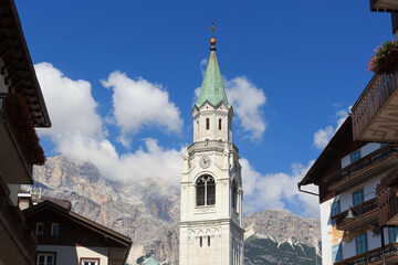 Basilica church steeple and mountain panorama view in Cortina d'Ampezzo, Italy