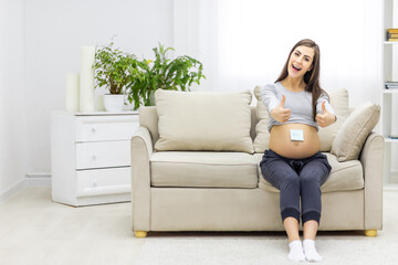 Obraz premium Photo of female abdomen with written word boy on the paper.