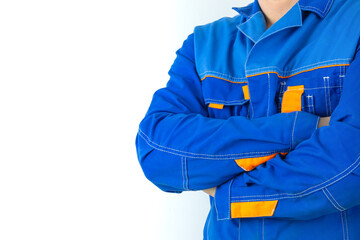 A man in blue work clothes on a white background with his arms crossed.