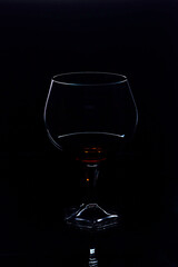 Glass with cognac on a black background