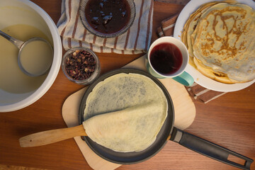 Pancake week. Preparation of dough for baking delicious and ruddy pancakes from the ingredients eggs, flour, butter and milk. Maslenitsa traditional Russian festival meal.
