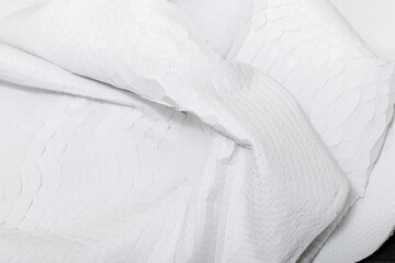 Obraz premium white genuine natural python leather on the wooden table 