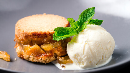 apple pie on plate with a scoop of vanilla ice cream