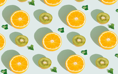 Fototapeta na wymiar Pattern with oranges, kiwis and leaves on a pastel blue background. Top view of tropical fruits, banner background. Flat lay citrus fruit and kiwi.