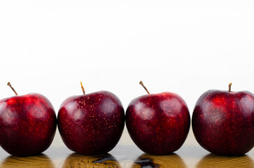 Apple, red, juicy. Apples are laid out in a row on the table. Fruit