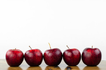 Apple, red, juicy. Apples are laid out in a row on the table. Fruit