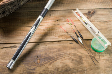 Fishing rod and floats on a wooden pallet. Fishing rod and various floats. Reel and bait box....