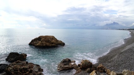 Crystal clear turquoise water, waves crashing on the rocky shore, and the ruins