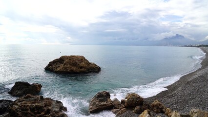 Crystal clear turquoise water, waves crashing on the rocky shore, and the ruins