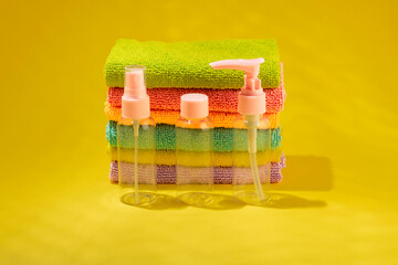 A set of transparent containers for cosmetics, colored towels on a colorful bright background.
