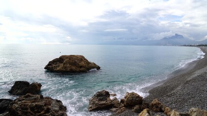 Crystal clear turquoise water, waves crashing on the rocky shore, and the ruins