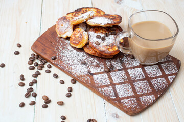 cheese pancakes  with coffee on a wood chopper. Home made breakfast display.