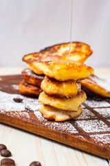 dripping honey on cheese pancakes, close up side view