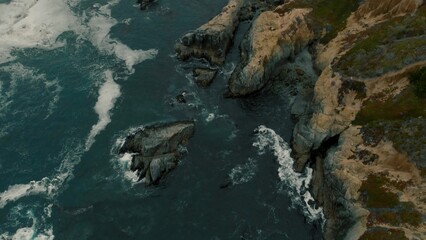 Crystal clear turquoise water, waves crashing on the rocky shore, and the ruins