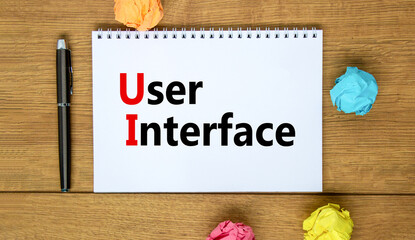 UI user interface symbol. Concept words UI user interface on white note. Metallic pen. Beautiful wooden background. Copy space. Business and UI user interface concept.