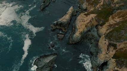 Crystal clear turquoise water, waves crashing on the rocky shore, and the ruins