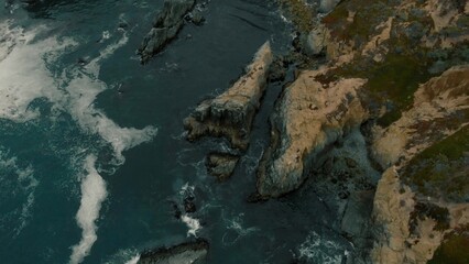 Crystal clear turquoise water, waves crashing on the rocky shore, and the ruins