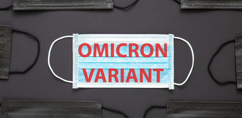 New Omicron variant covid 19 text on face mask isolated on black background. Omicron positive text...