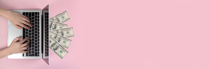 Laptop keyboard and dollar bills. Banner. Female hands typing on wireless keyboard, flat lay workspace. Freelance concept, pink background, top view and copy space photo